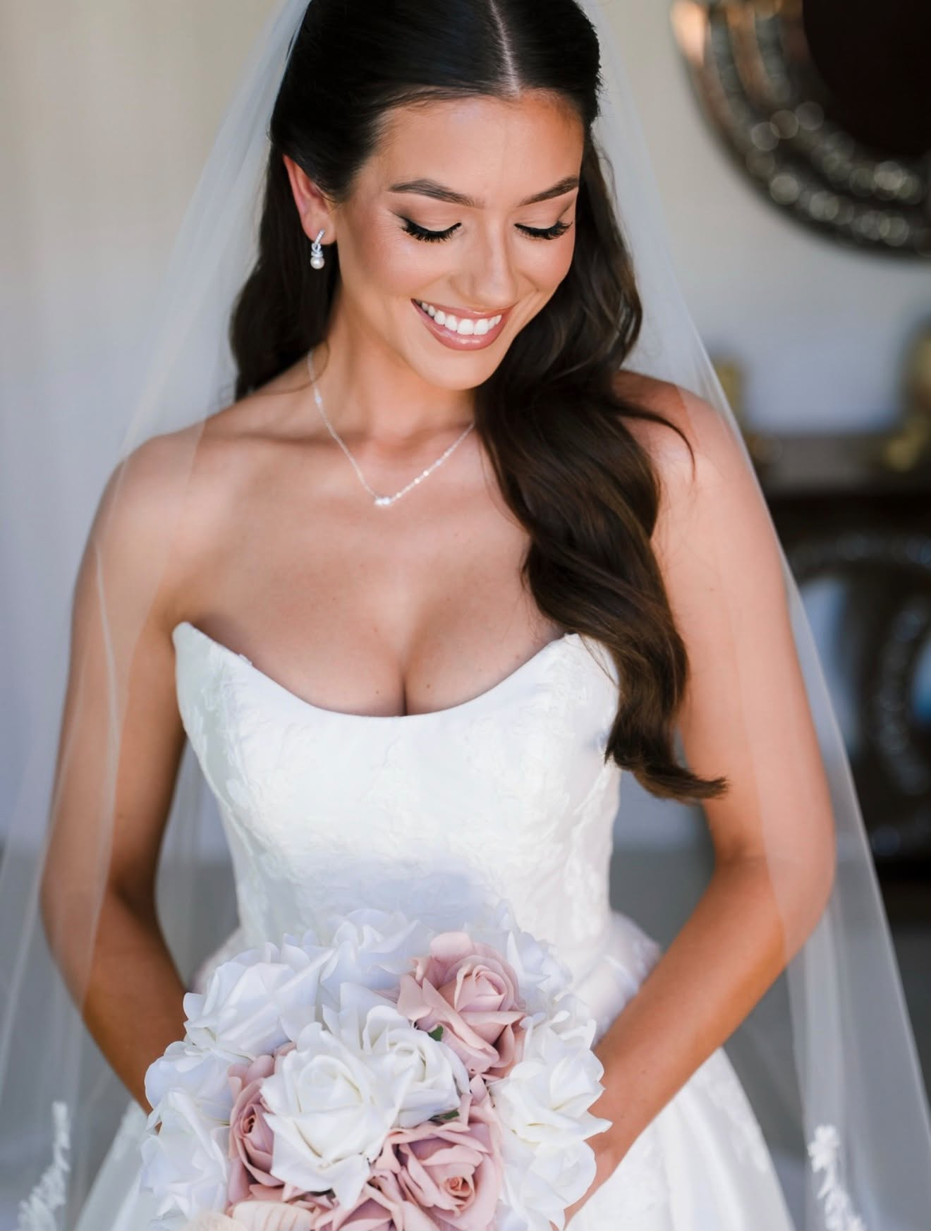 Bridal portrait showing softly defined eye makeup, glowing skin and a white veil